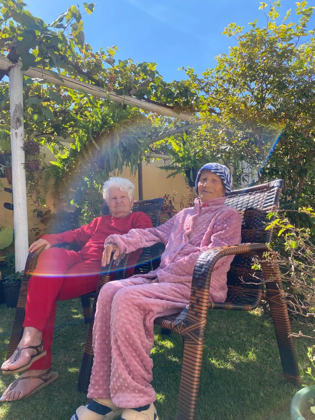 Residentes relaxando e aproveitando a manhã ensolarada no jardim arborizado